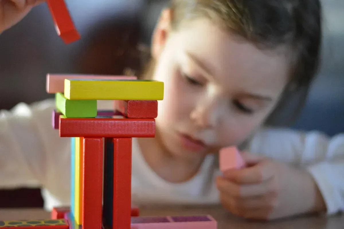 Child building a colorful block tower during a hands-on learning activity